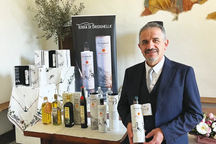 Il presidente di Cab accanto a un tavolo con molti prodotti esposti della cooperativa