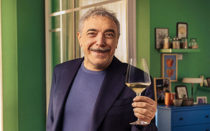Nino Frassica, testimonial della nuova campagna di Tavernello, con un bicchiere di vino in mano