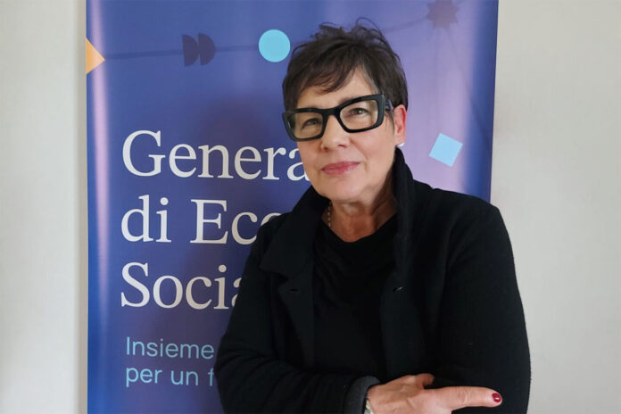 Una foto di Maria Martinelli davanti a un manifesto di un evento