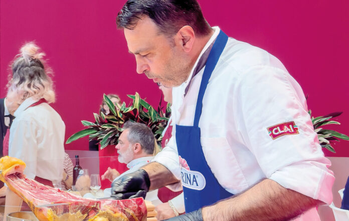 Un macellaio di Clai che taglia un pezzo di carne con il coltello