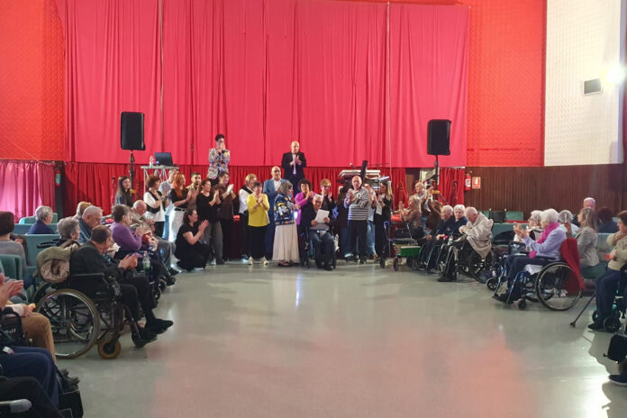 Una sala con tanti anziani messi in cerchio