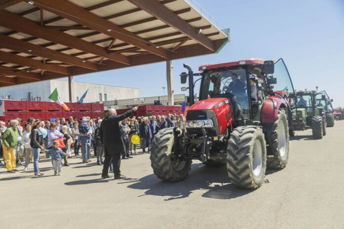 Il parroco alla Festa della cooperazione che benedice le macchine agricole